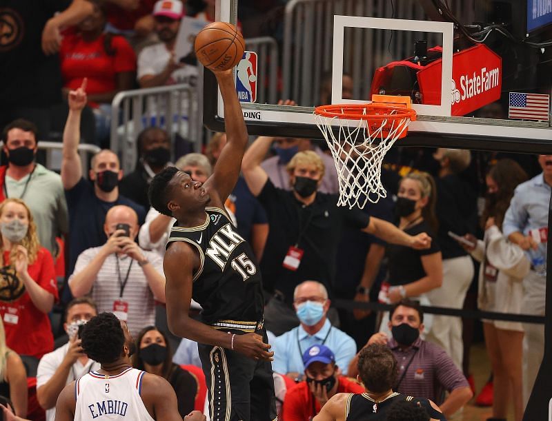 Clint Capela #15 lays in a basket against Joel Embiid #21.