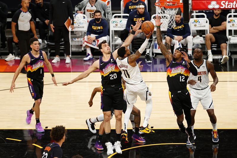 Monte Morris #11 puts up a shot over Devin Booker #1 and Torrey Craig #12 during the first half in Game One