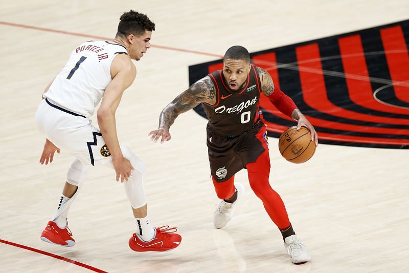 Damian Lillard #0 of the Portland Trail Blazers dribbles against Michael Porter Jr. #1 of the Denver Nuggets during Round 1, Game 6 of the 2021 NBA Playoffs