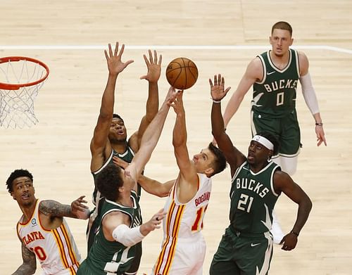 Guard Bogdan Bogdanovic #13 shoots over center Brook Lopez #11 and forward Giannis Antetokounmpo #34.