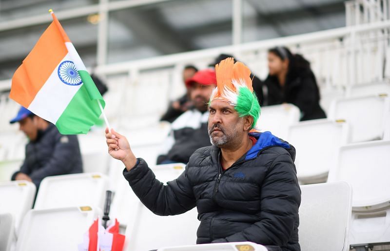 An Indian fan awaits the start of the play.