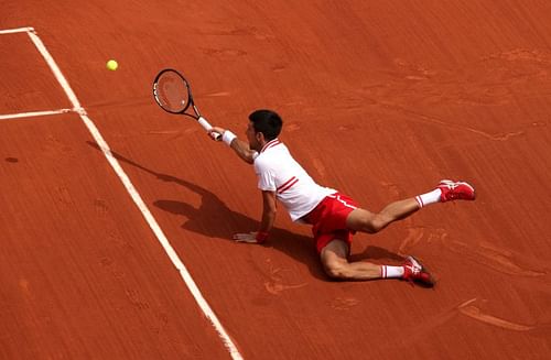 Novak Djokovic falls while returning