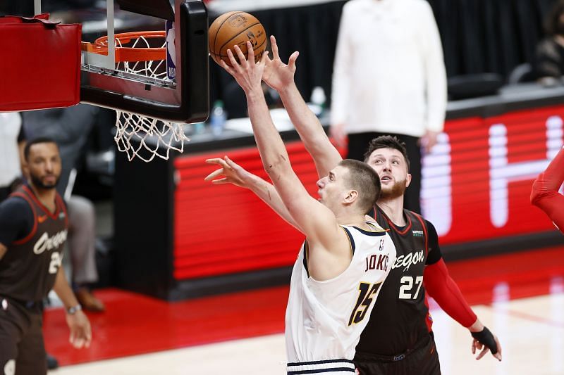 Nikola Jokic #15 of the Denver Nuggets shoots against Jusuf Nurkic #27 of the Portland Trail Blazers.