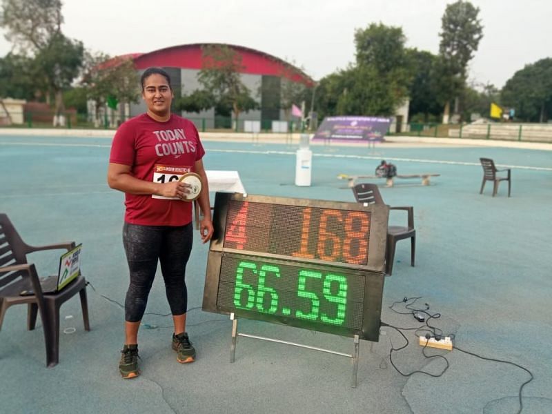 Kamalpreet Kaur standing in front of the scoreboard showing new national record (Credits: Athletics Federation of India/Twitter)