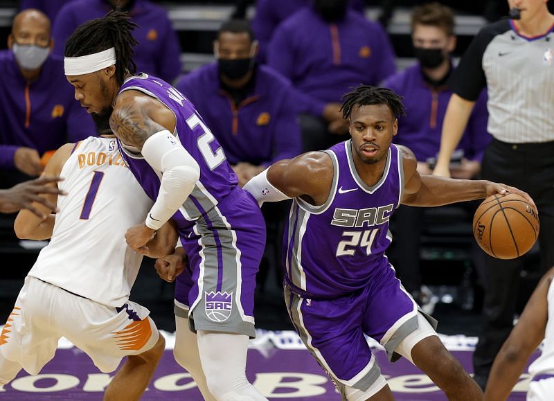 Buddy Hield #24 is guarded by Devin Booker #1.