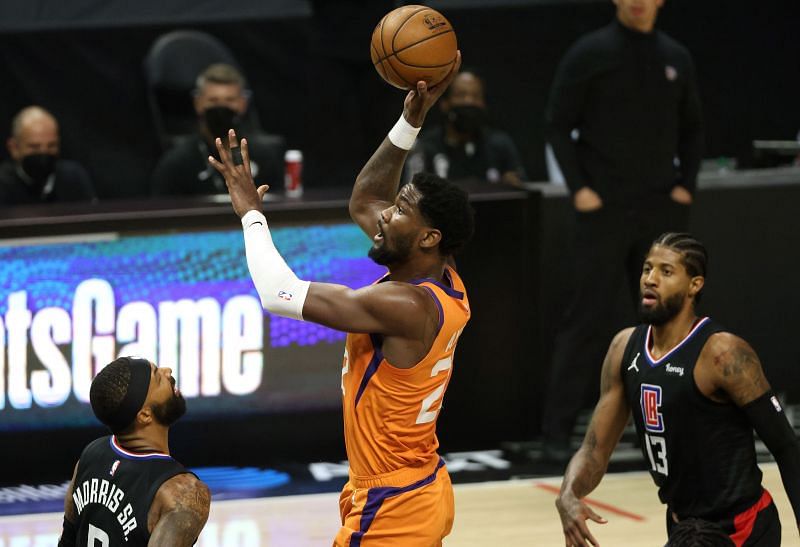 Deandre Ayton #22 attempts a shot between Marcus Morris Sr. #8 and Paul George #13