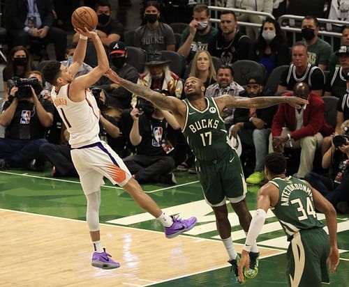 Devin Booker #1 takes a jump shot as P.J. Tucker #17.