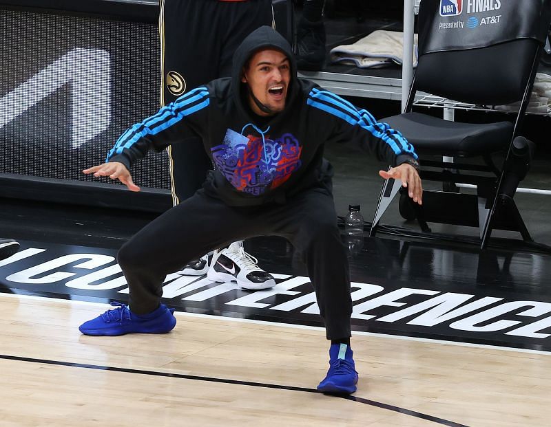 Trae Young cheers his teammates from courtside