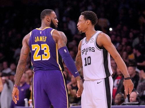 LeBron James #23 and DeMar DeRozan #10 talk on the court.