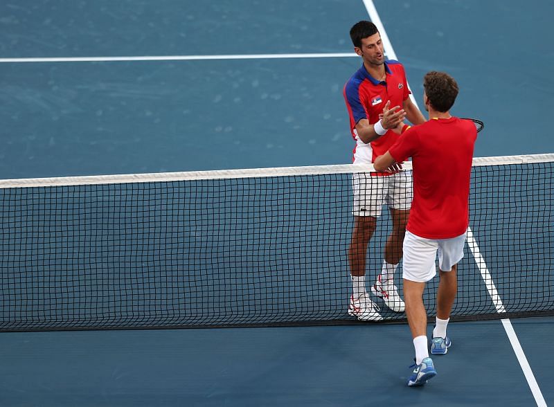 Novak Djokovic and Pablo Carreno Busta embrace at the net