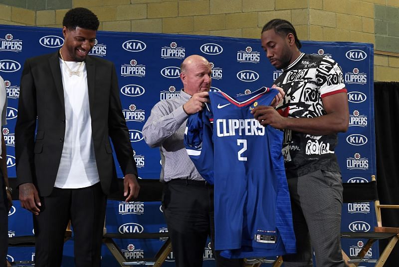 Clippers owner Steve Ballmer hands Kawhi Leonard his jersey as he and Paul George are introduced