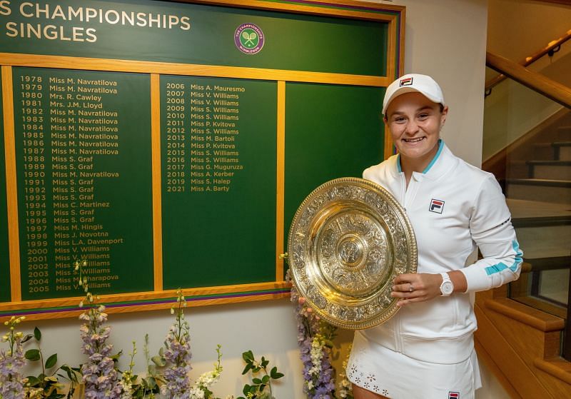 Ashleigh Barty posing with the Venus Rosewater Dish in front of the Wimbledon &quot;Wall of Champions&quot;