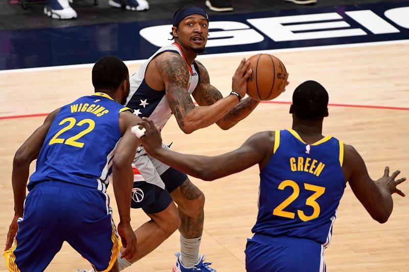 Bradley Beal #3 looks to shoot in front of Andrew Wiggins #22 and Draymond Green #23