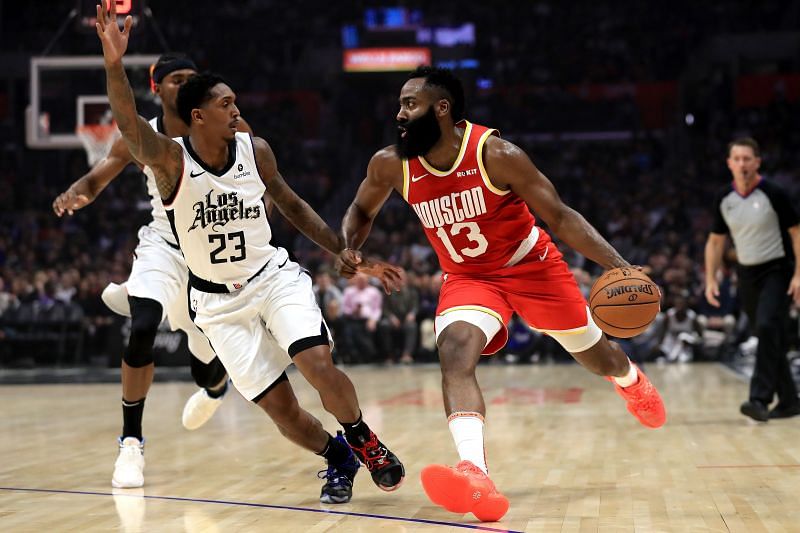 James Harden (#13) dribbles into the defense of Lou Williams (#23).