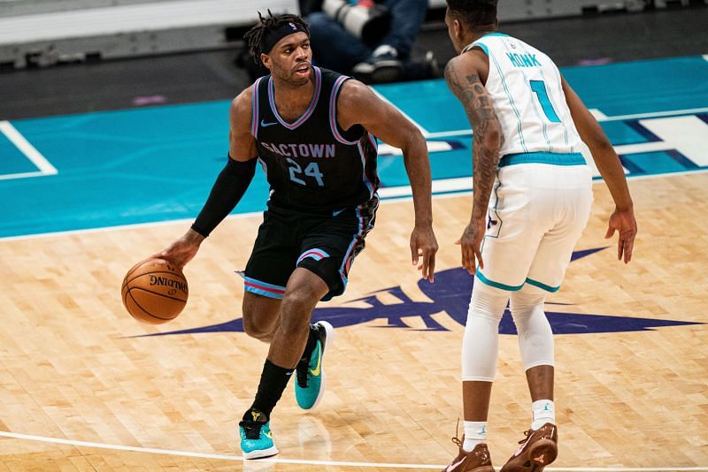Buddy Hield #24 brings the ball up court while guarded by Malik Monk #1.