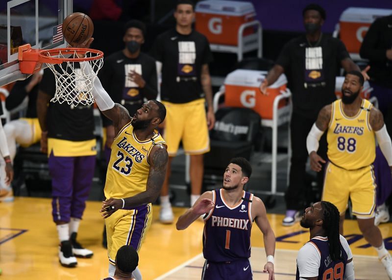 LeBron James (#23) scores on a lay-up in front of Devin Booker (#1) and Jae Crowder (#99).