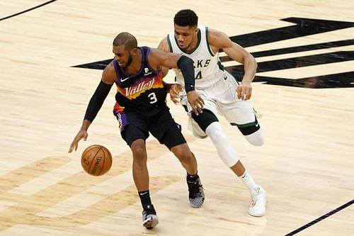 Giannis Antetokounmpo tussles with Chris Paul for possession