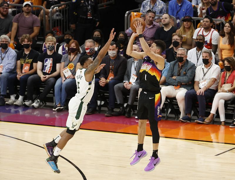 Devin Booker #1 shoots against Jeff Teague #5.