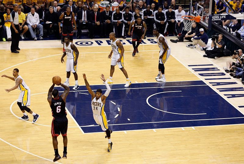 LeBron James #6 attempts a three-point shot against Paul George #24.