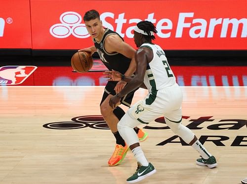 Bogdan Bogdanovic #13 of the Atlanta Hawks is defended by Jrue Holiday #21 of the Milwaukee Bucks.