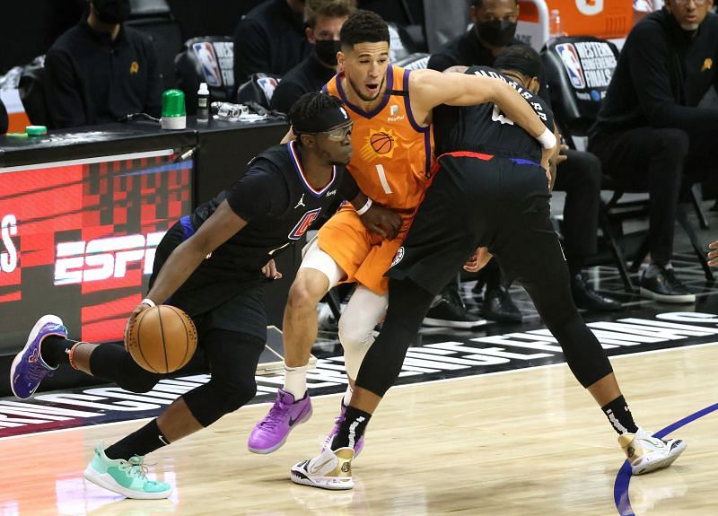 Reggie Jackson #1 drives past Devin Booker #1.