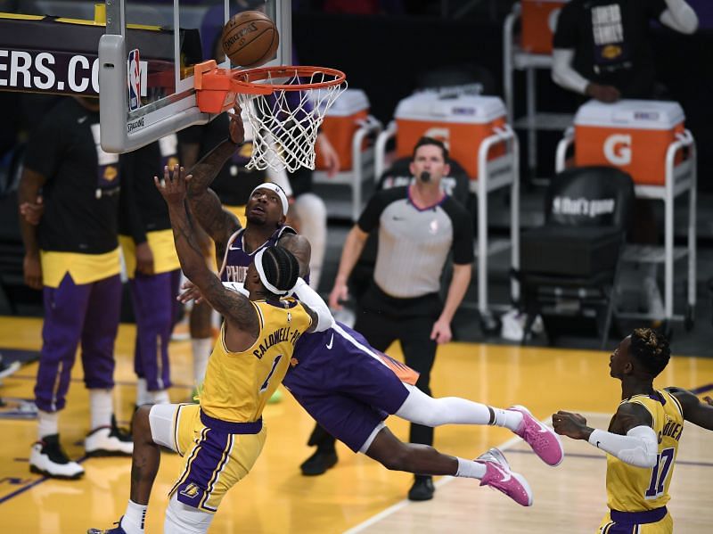 Kentavious Caldwell-Pope #1 and Dennis Schroder #17 of the Los Angeles Lakers defend Torrey Craig #12 of the Phoenix Suns