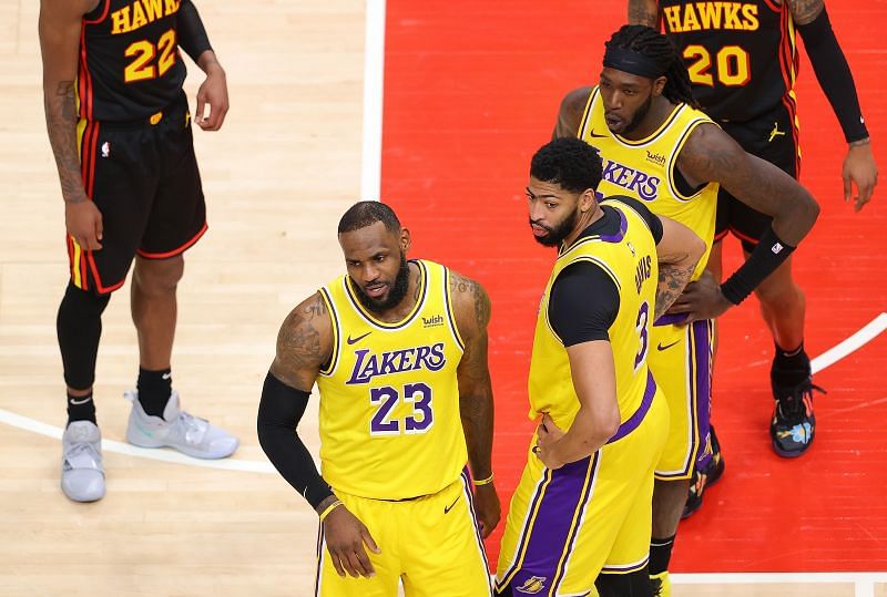 LeBron James (#23) of the LA Lakers on the floor next to teammate Anthony Davis (#3)