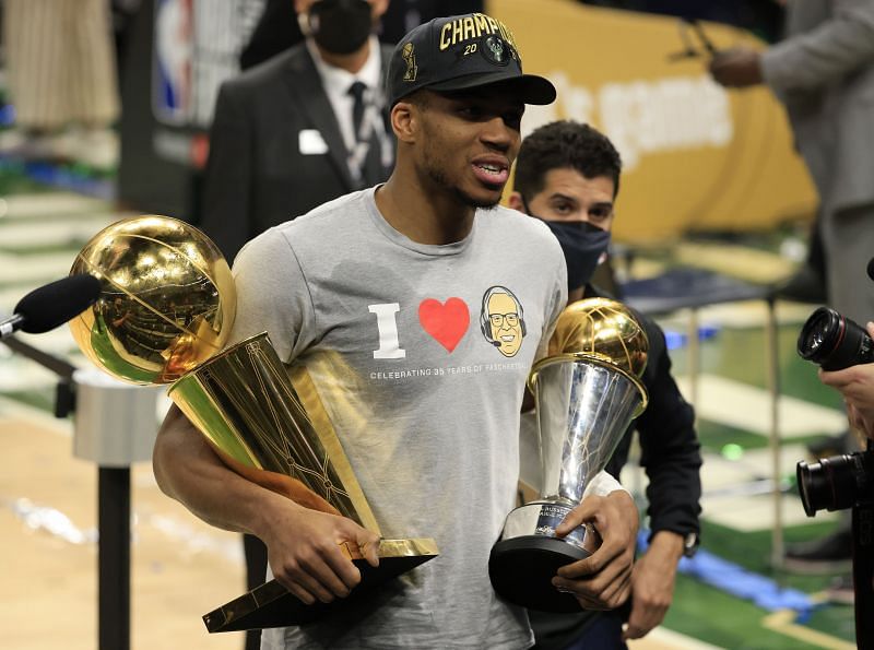 Giannis Antetokounmpo #34 of the Milwaukee Bucks holds the Bill Russell NBA Finals MVP Award and the Larry O&#039;Brien Championship Trophy