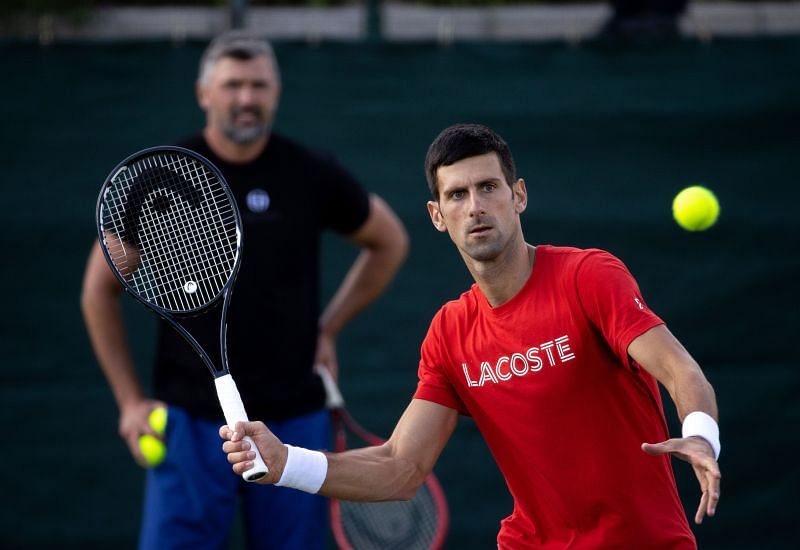 Novak Djokovic practices as Goran Ivanisevic (L) looks on