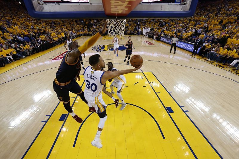 Stephen Curry #30 throws up a shot against LeBron James #23.