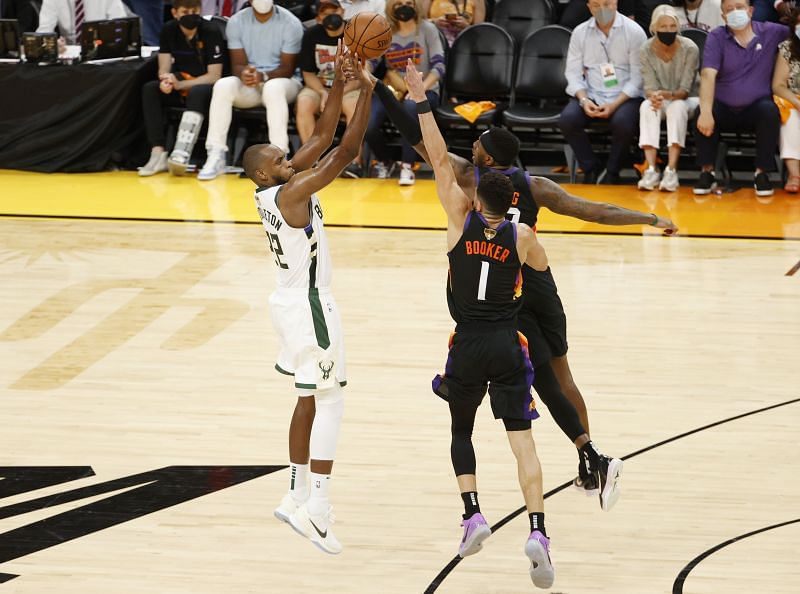 Khris Middleton #22 shoots against Devin Booker #1