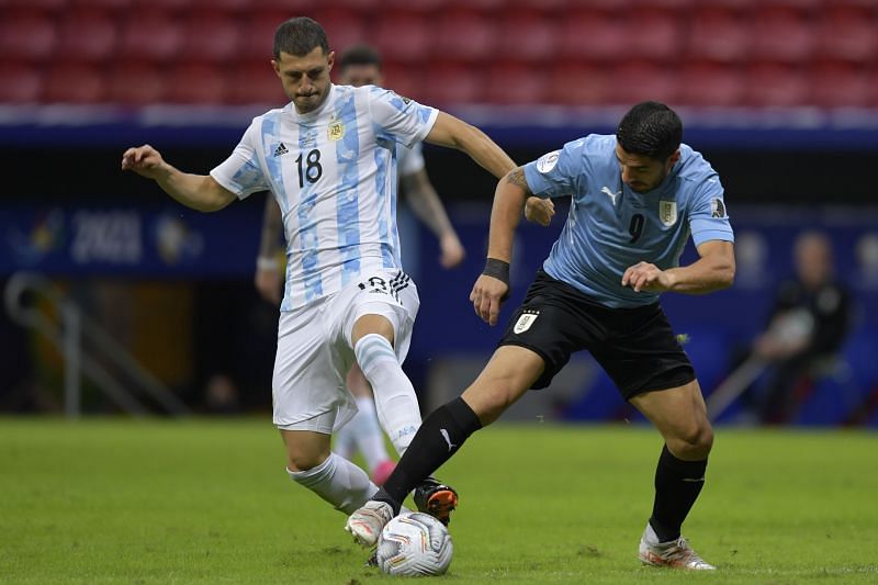 Guido Rodriguez battles for the ball with Luis Suarez