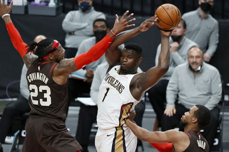 Zion Williamson (#1) looks to pass while pressured by Robert Covington (#23).