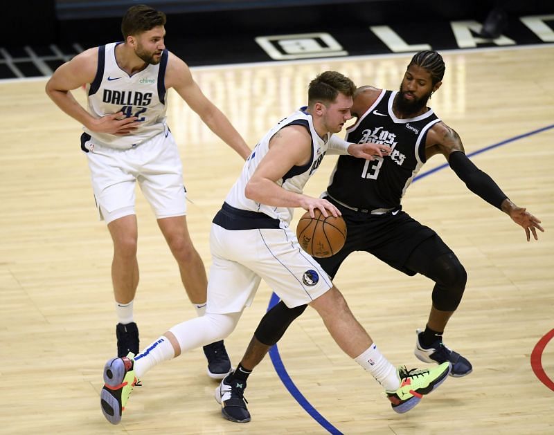 Luka Doncic #77 of the Dallas Mavericks fouls Paul George #13 of the LA Clippers.