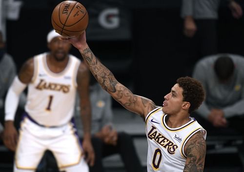 Kyle Kuzma #0 scores on a layup in front of Kentavious Caldwell-Pope #1 during a preseason game