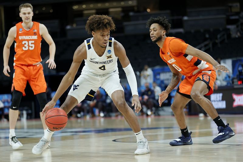 Miles McBride #4 of the West Virginia Mountaineers controls the ball against Alan Griffin #0.