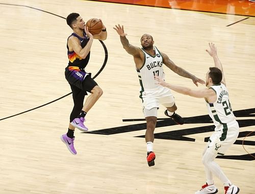 Devin Booker #1 shoots against P.J. Tucker #17