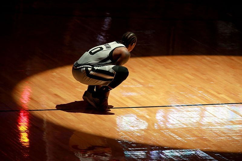 DeMar DeRozan #10 kneels on the court prior to the start of an NBA game.