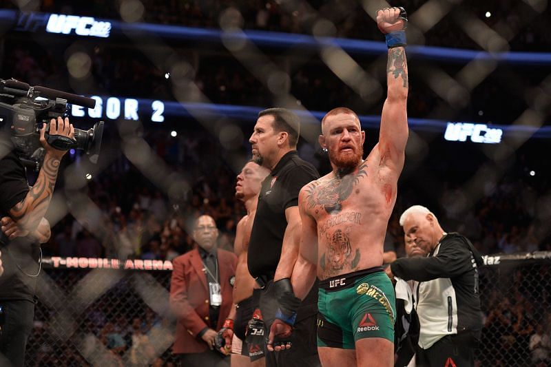 Conor McGregor (right) raises his hand at UFC 202.