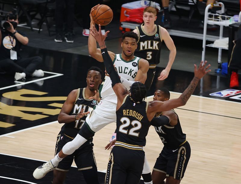 Giannis Antetokounmpo (#34) looks to pass against Onyeka Okongwu (#17), Cam Reddish (#22) and Kris Dunn (#32).