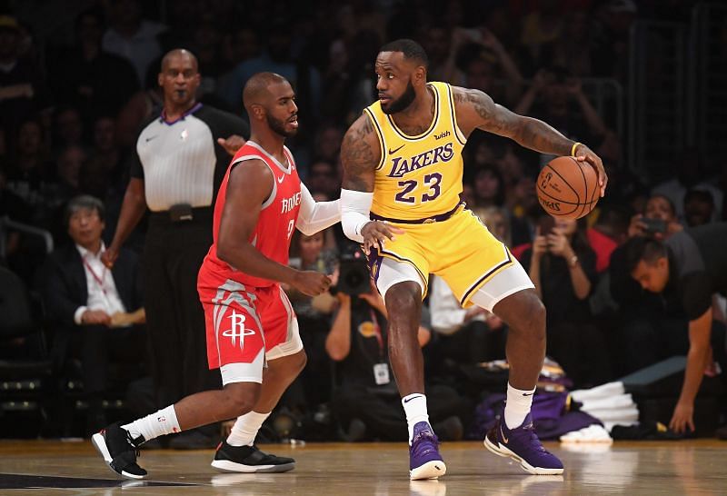 LeBron James #23 of the Los Angeles Lakers dribbles the ball against Chris Paul