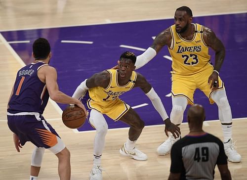 Dennis Schroder #17 and LeBron James #23 of the Los Angeles Lakers double team Devin Booker #1 of the Phoenix Suns