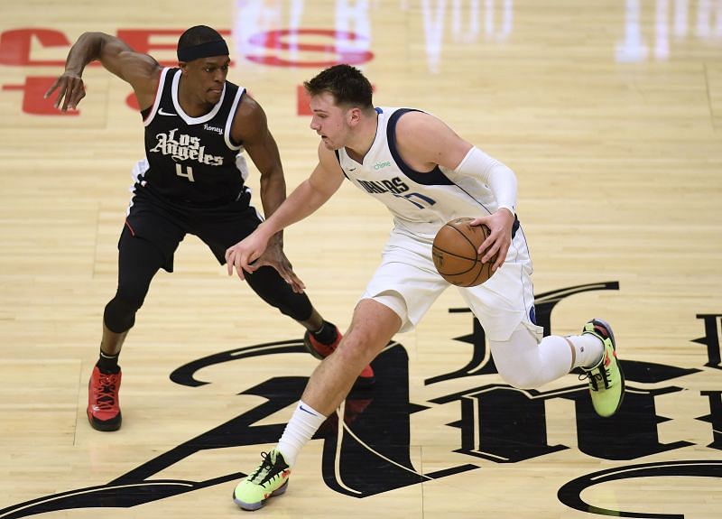 Luka Doncic #77 dribbles in front of Rajon Rondo #4.