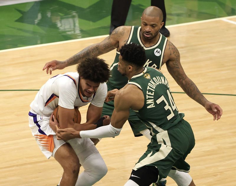 Cameron Johnson #23 and Giannis Antetokounmpo #34 battle for possession of the ball.