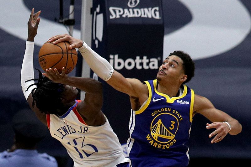 Jordan Poole blocks a shot (right)