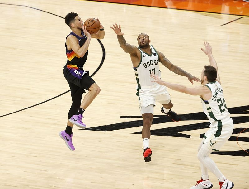 Devin Booker #1 shoots against P.J. Tucker #17 of the Milwaukee Bucks and Pat Connaughton #24.