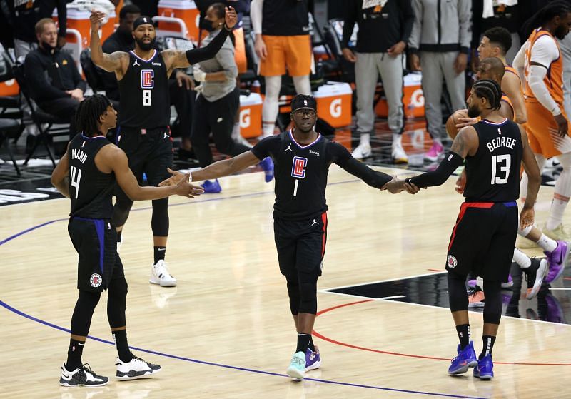 The LA Clippers&#039; Reggie Jackson #1 reacts to a basket and a foul with teammates Terance Mann #14 and Paul George #13