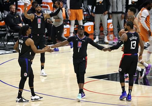 The LA Clippers' Reggie Jackson #1 reacts to a basket and a foul with teammates Terance Mann #14 and Paul George #13