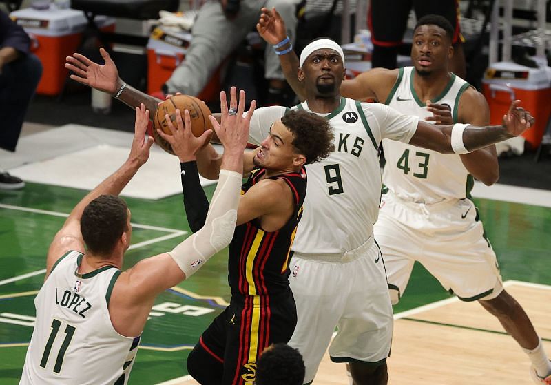 Trae Young #11 of the Atlanta Hawks is pressured by Brook Lopez #11 and Bobby Portis #9 of the Milwaukee Bucks
