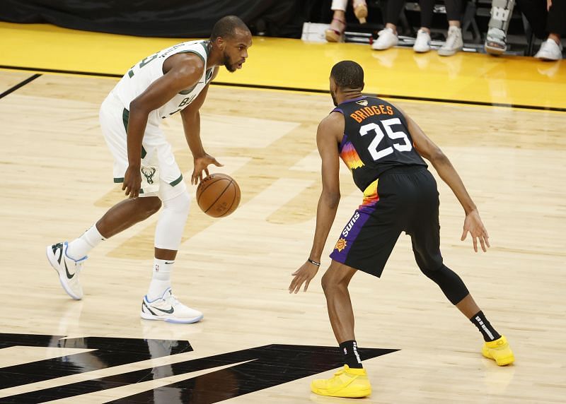 Khris Middleton #22 brings the ball up court against against Mikal Bridges #25.